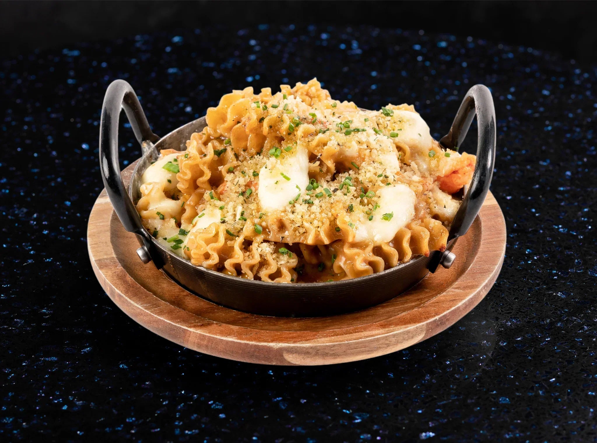 Rich and creamy lobster mac & cheese topped with golden crispy breadcrumbs, served in a skillet.