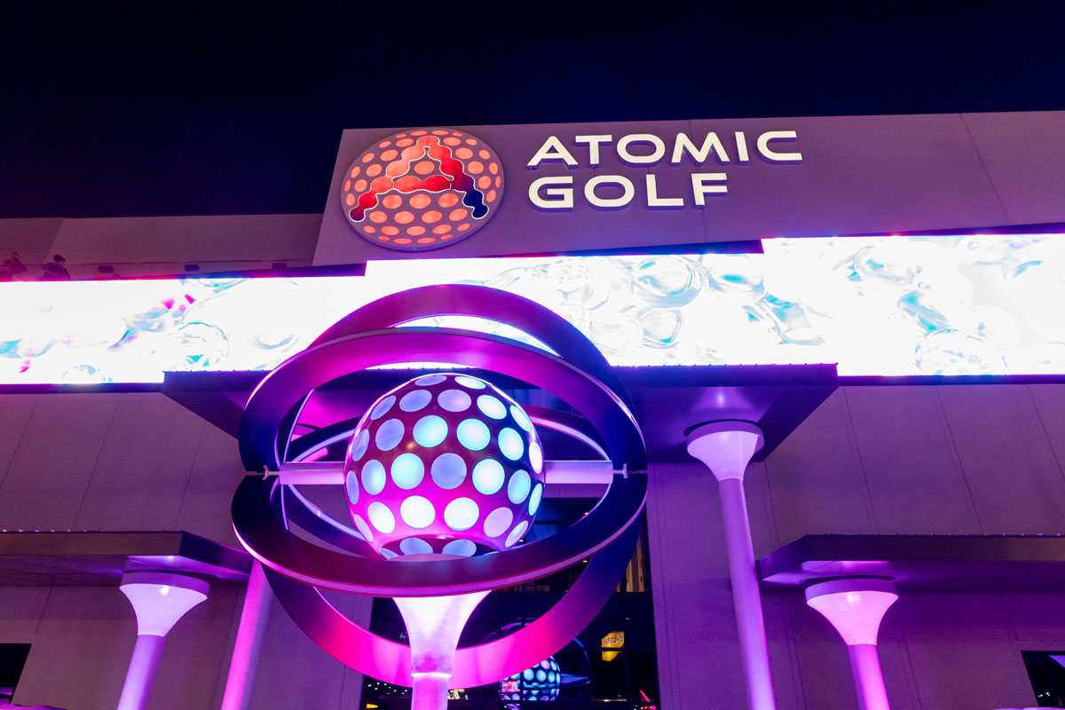 A high-tech Atomic Golf bay with digital features next to a colorful, themed mini-golf course.