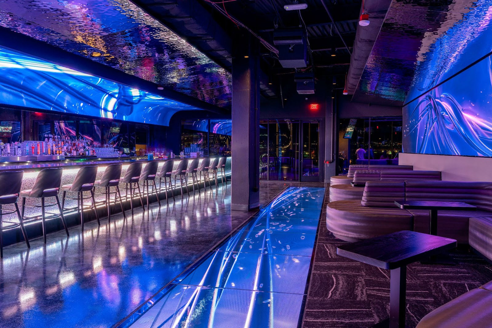 A glowing golf course at Atomic Golf with players enjoying the nightlife experience.