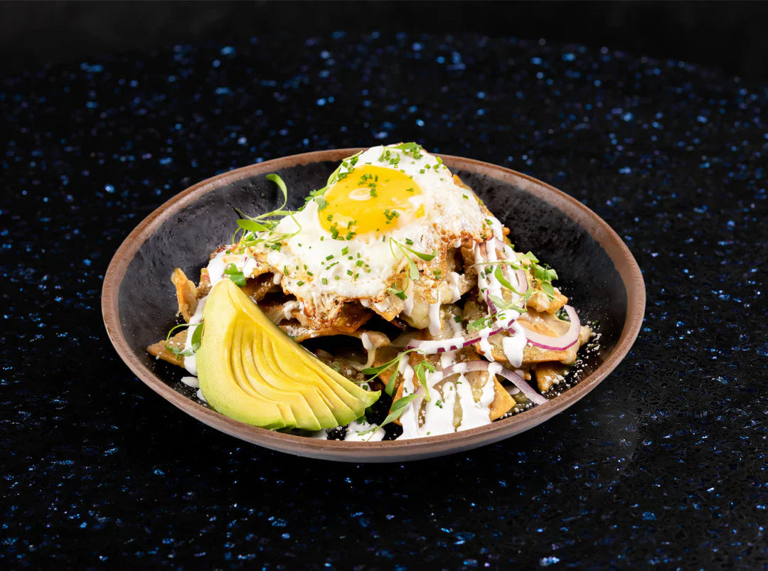 Crispy tortilla chips smothered in salsa verde, topped with melted cheese, sour cream, cotija, and a perfectly fried egg.