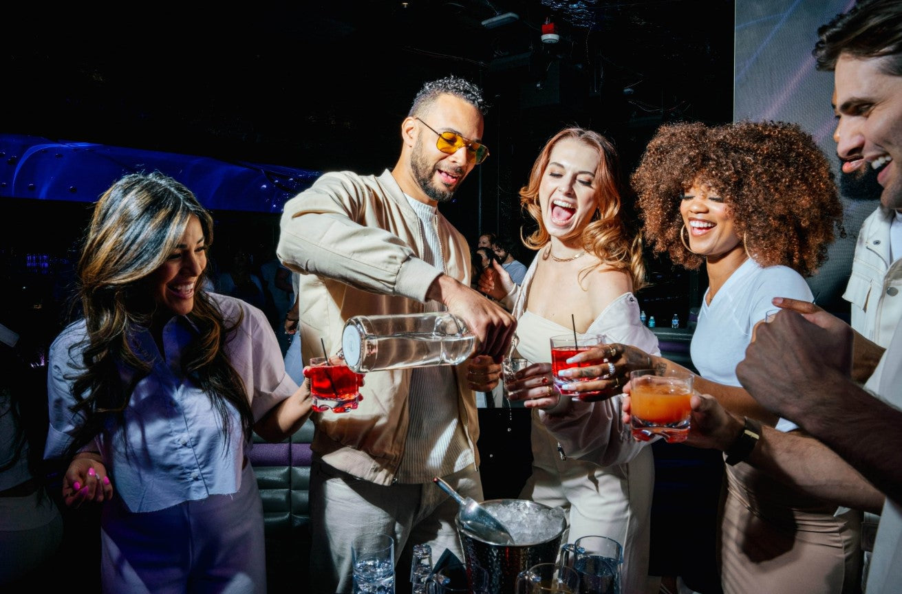 Guests enjoying a lively Friday night party at Atomic Golf with drinks and golf.